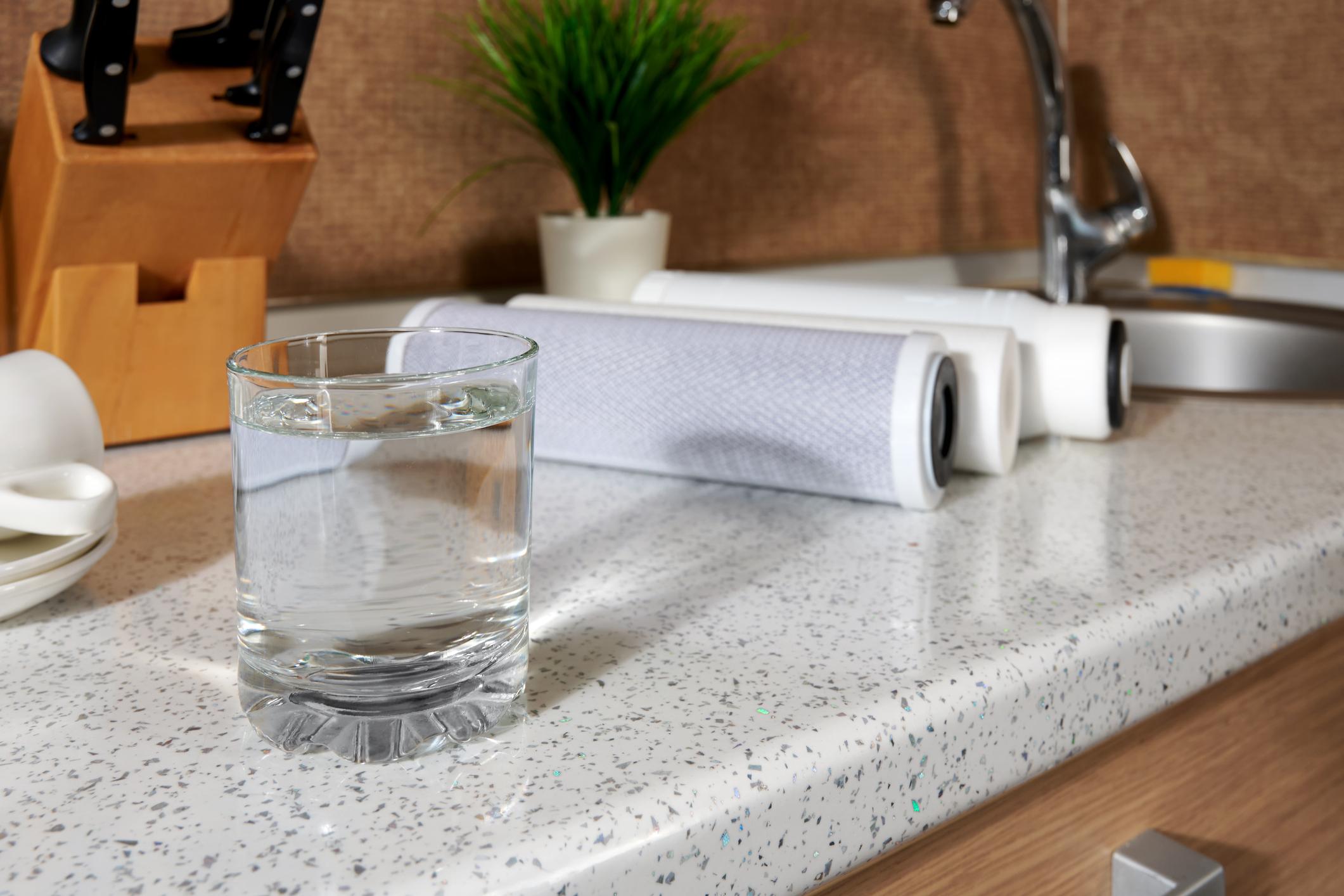 Kökskran med glas rent dricksvatten i modernt kök